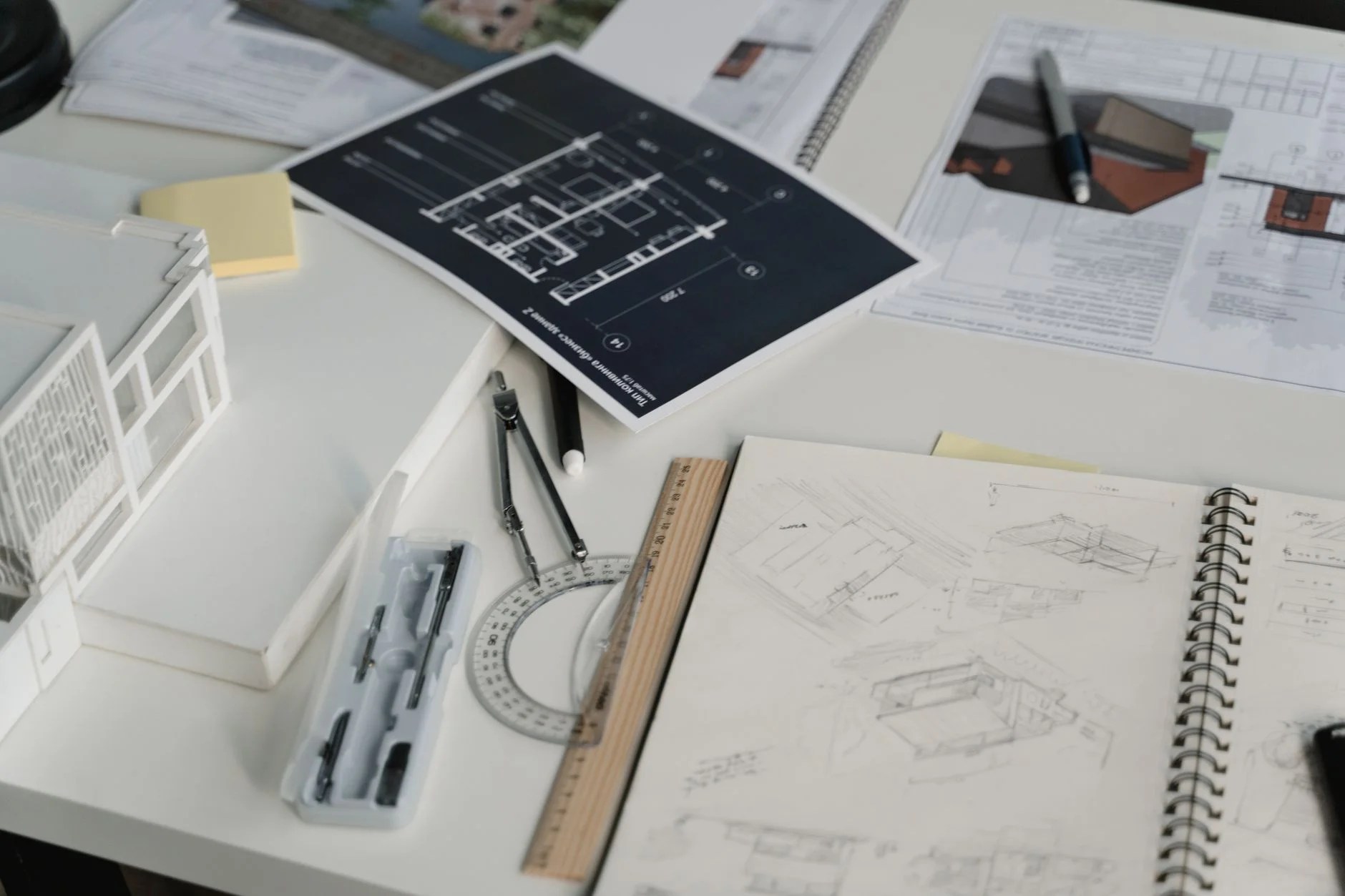 Technical drawings, a compass, and drafting instruments laid out on a desk, representing the engineered documents inside a supplier bid package