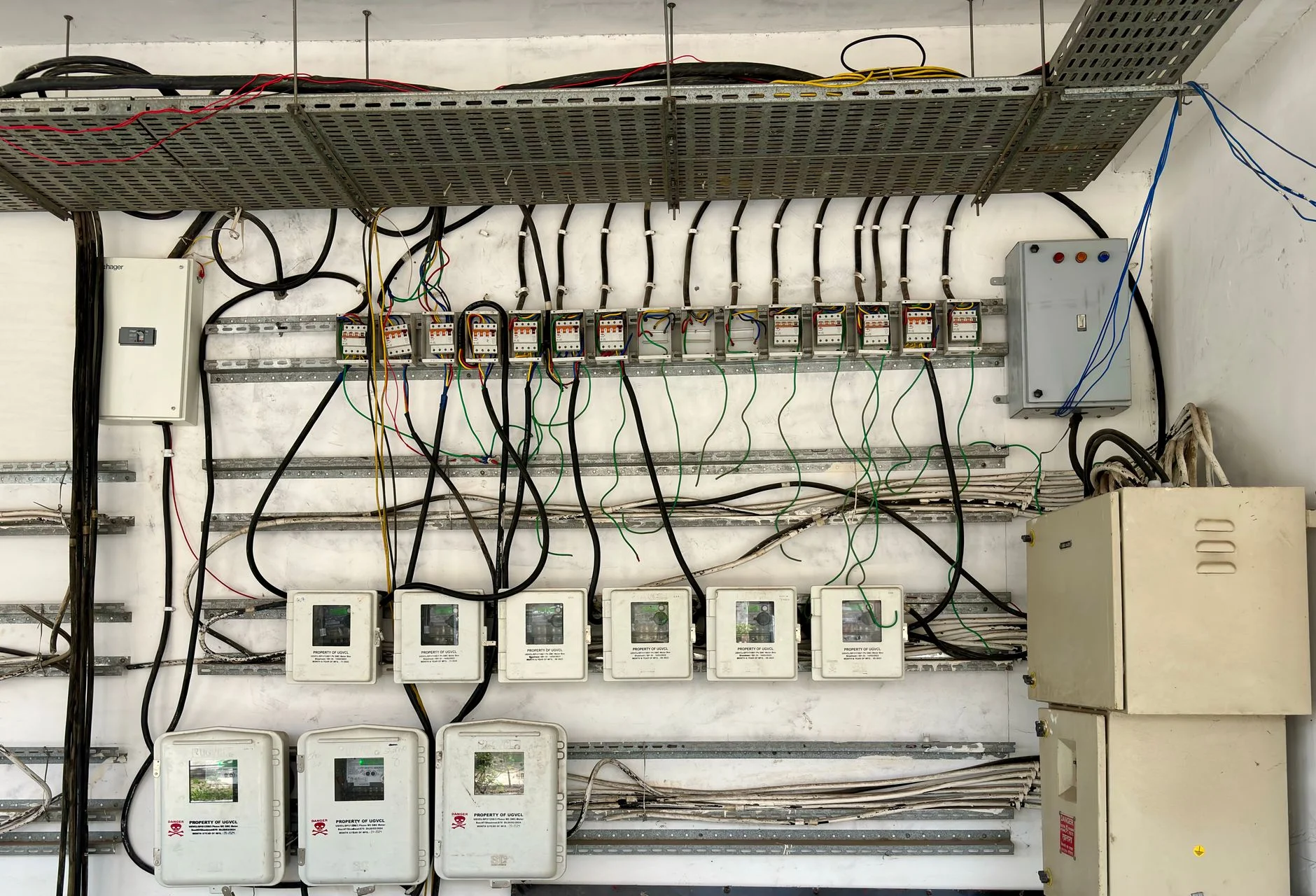 A real industrial wiring panel, meters and cable runs assembled over years rather than designed in one pass