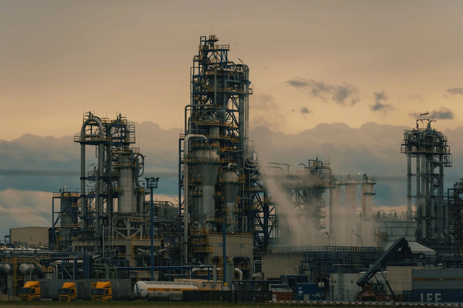 Refinery towers and process columns at dusk, representing the scale of the industrial tenders that bid committees evaluate