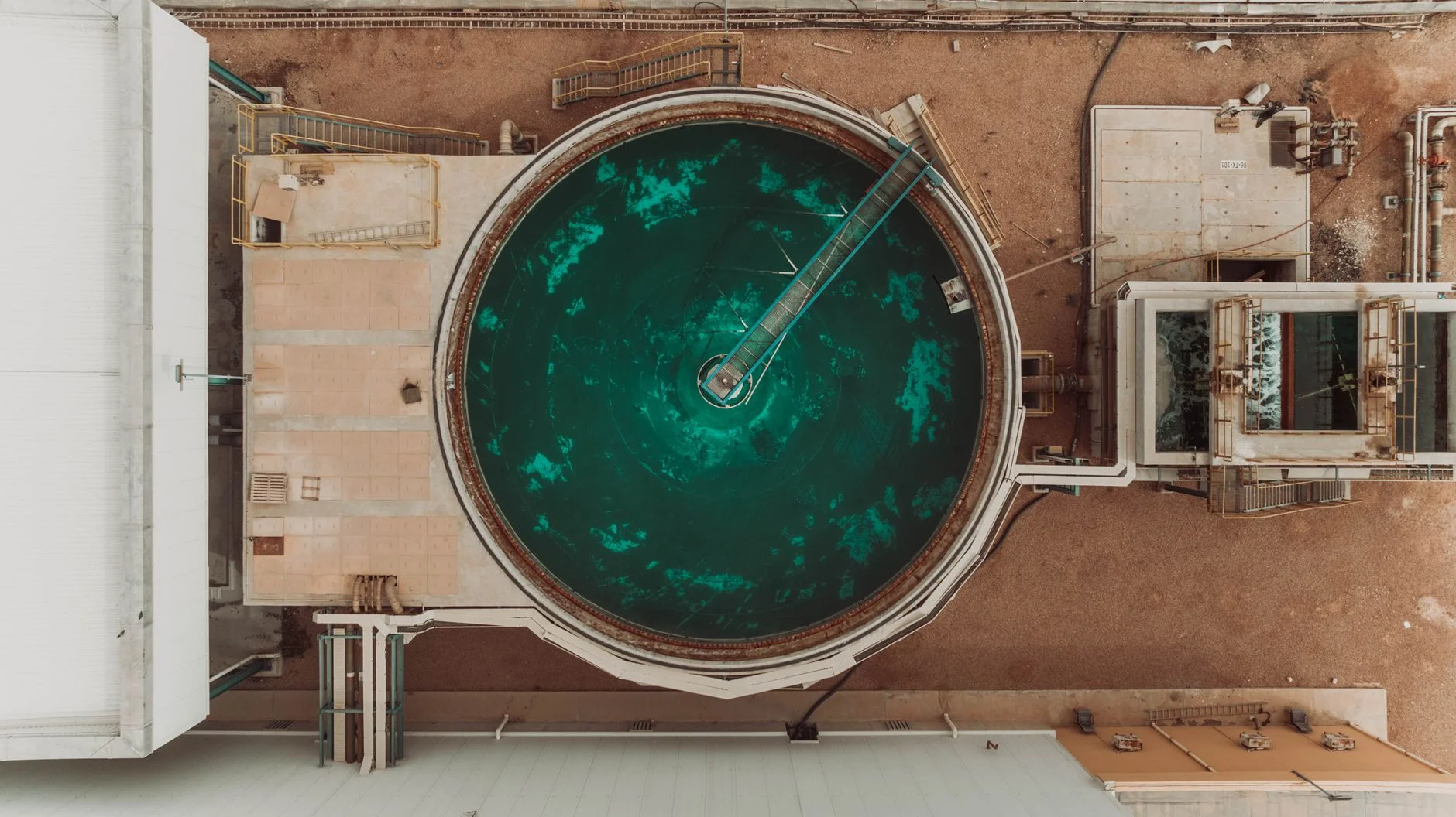 Aerial view of a circular water treatment clarifier tank at an industrial facility