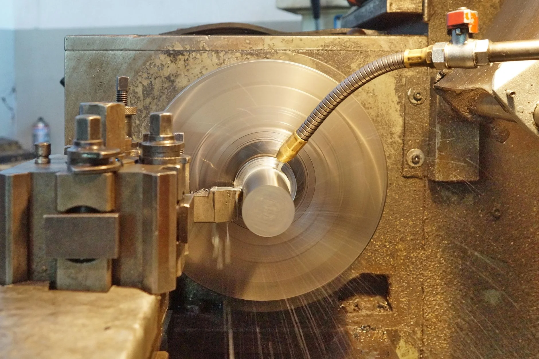 A metal workpiece spinning in a precision lathe during a turning operation