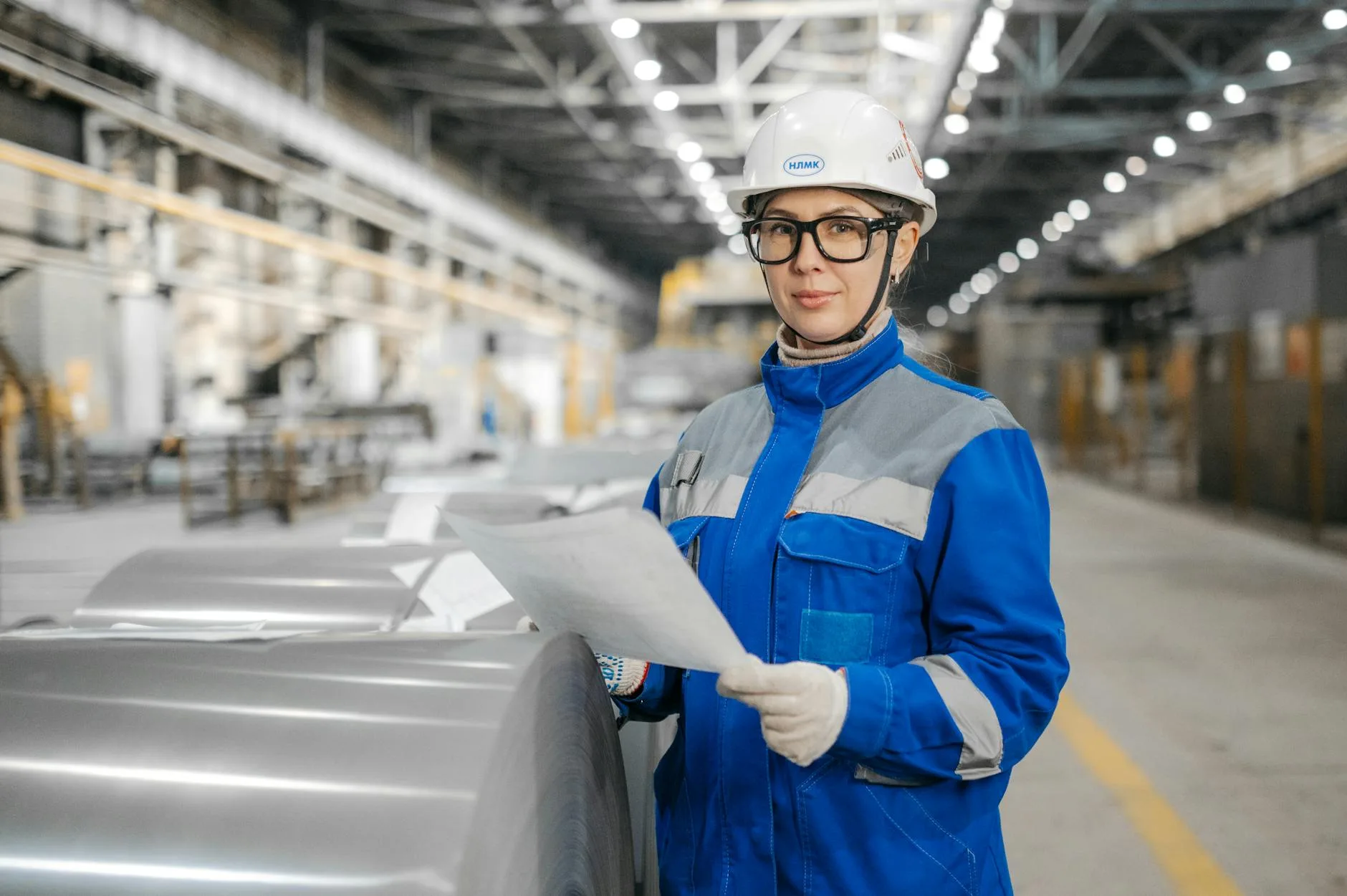 Engineer reviewing technical documents in an industrial plant, the work that decides whether a quote becomes revenue.